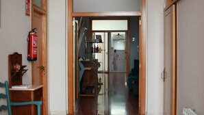 Un pasillo con un marco de puerta de madera, un extintor y un radiador.