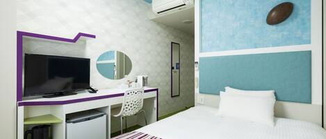 Une chambre d’hôtel équipée d’un lit, d’un bureau avec un ordinateur, d’un miroir et d’un climatiseur fixé au mur.