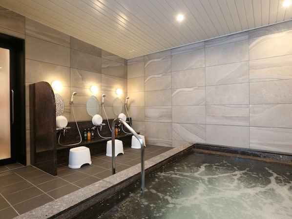 Une salle de bain moderne avec une grande baignoire, plusieurs lavabos et un miroir.