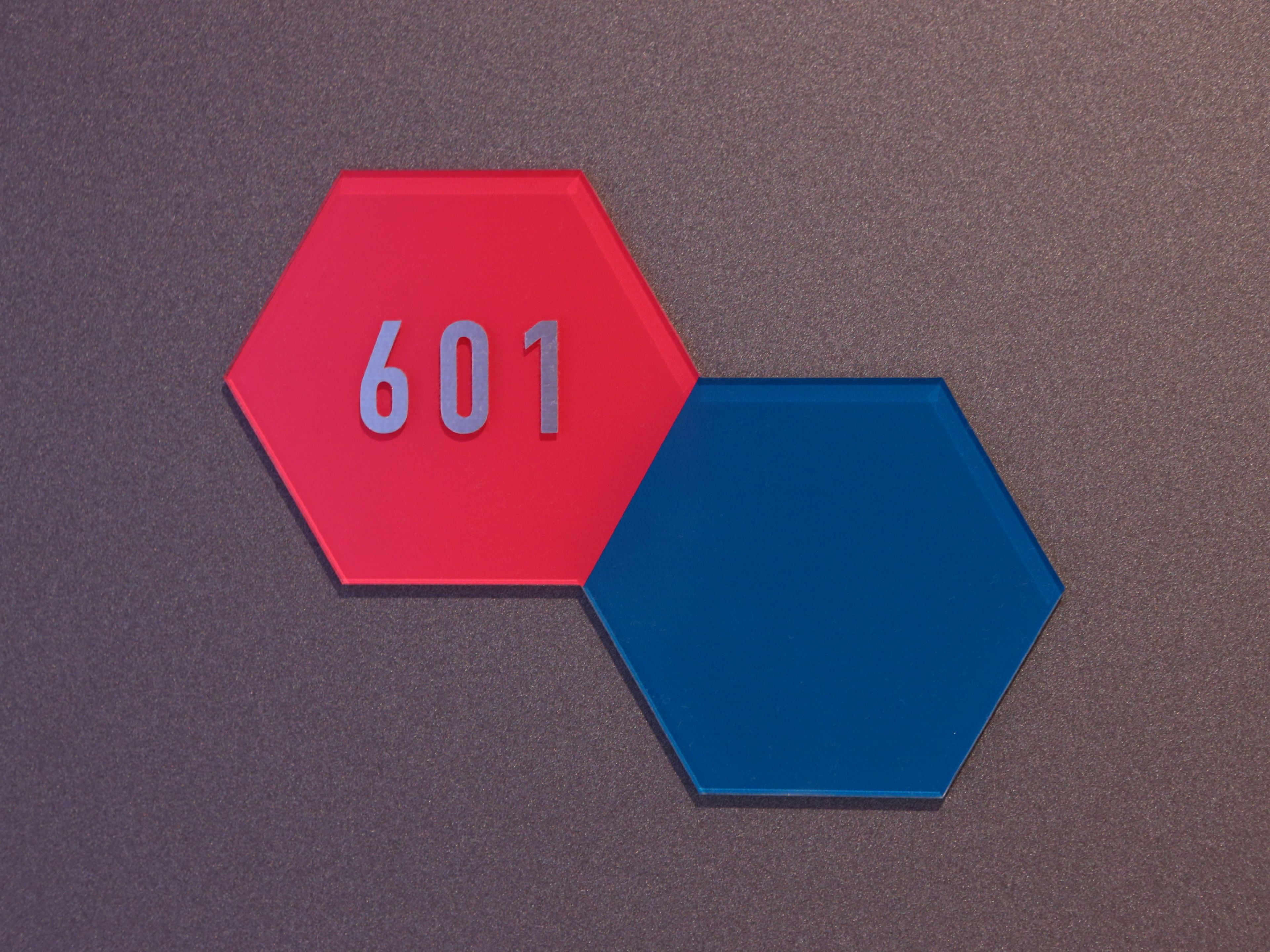 A red hexagonal sign with the number 601 on a textured surface.