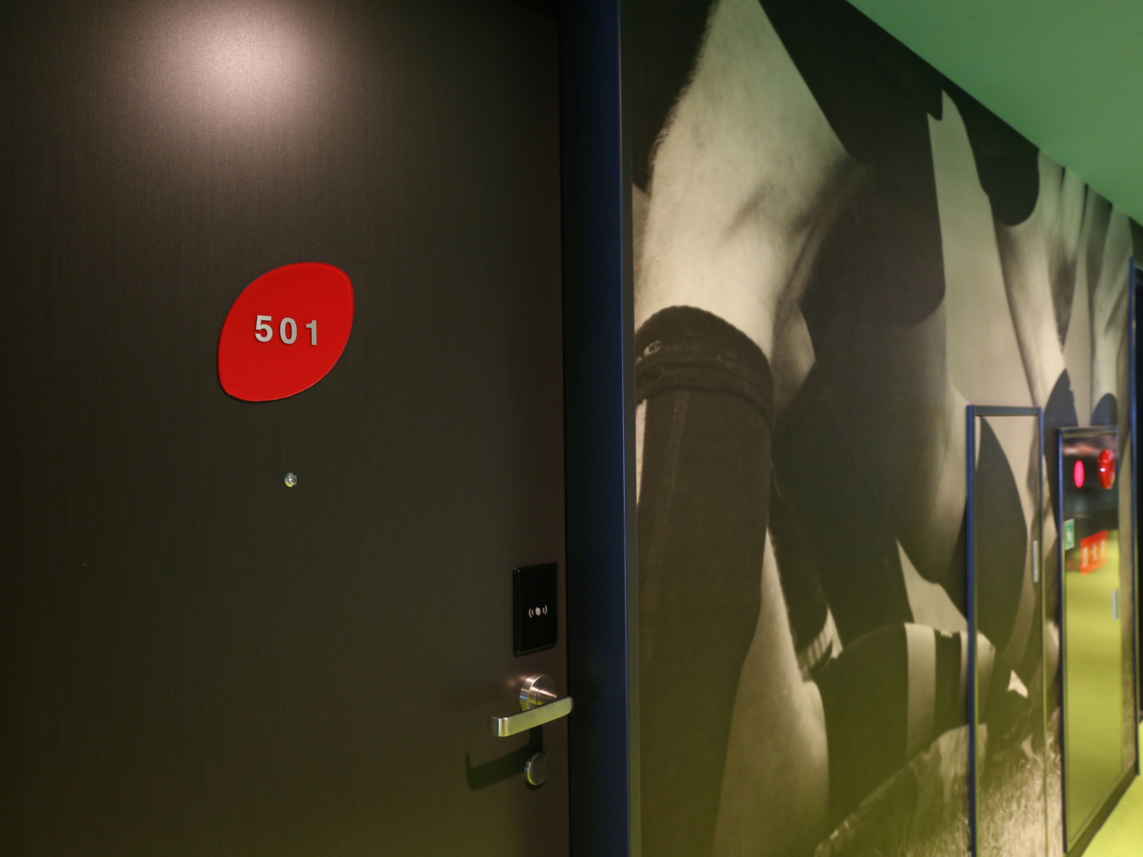 A hotel room door with a red number sign '501' and a keycard slot.
