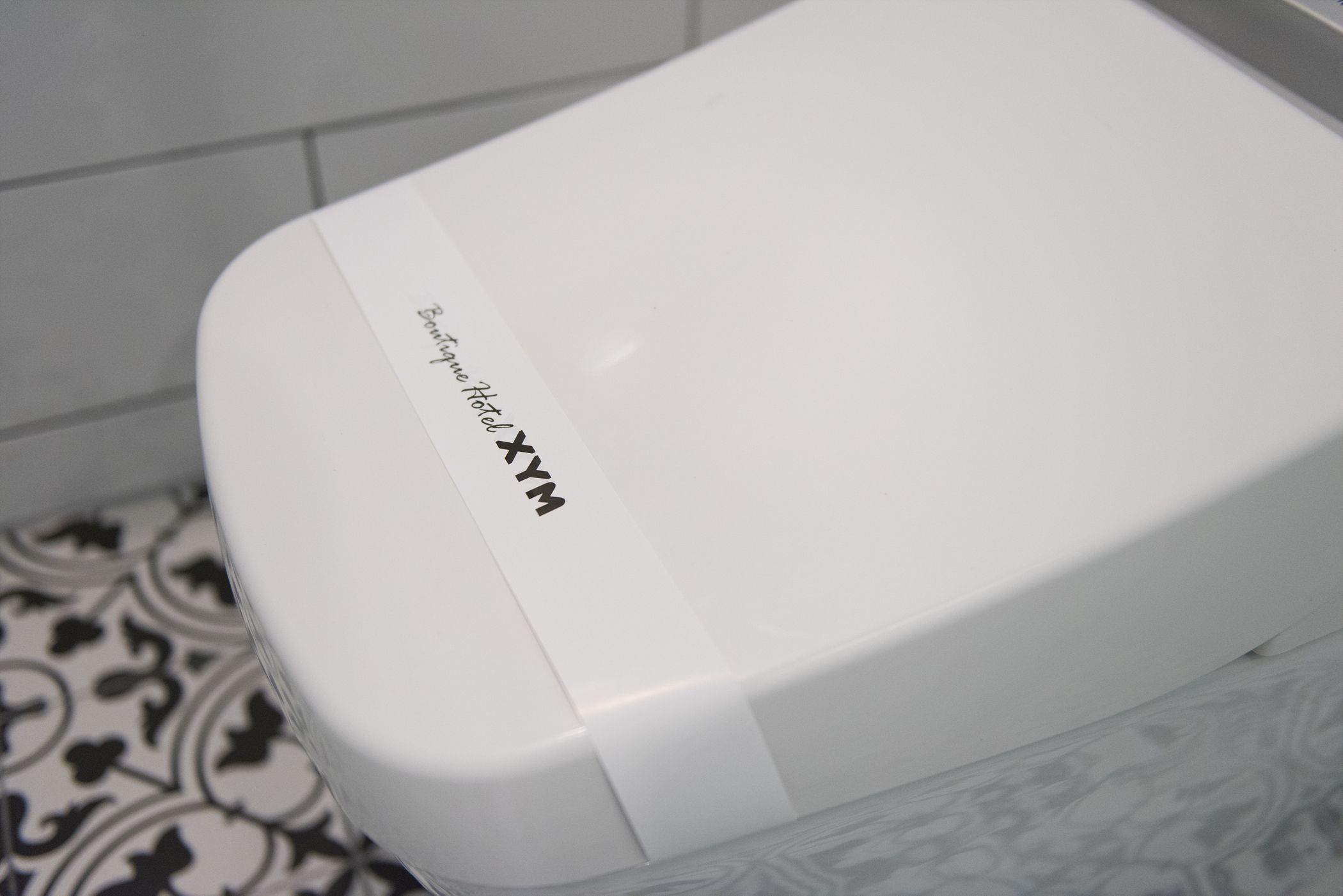 Een witte hotelkamer met een badkamer en een vloer met een patroon.