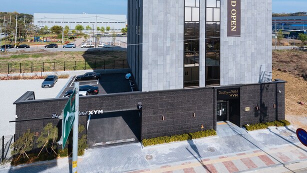 A modern hotel building with a prominent sign reading "Boutique Hotel XYZM Grand Open". - Boutique Hotel XYM Pyeongtaek (Pyeongtaek)