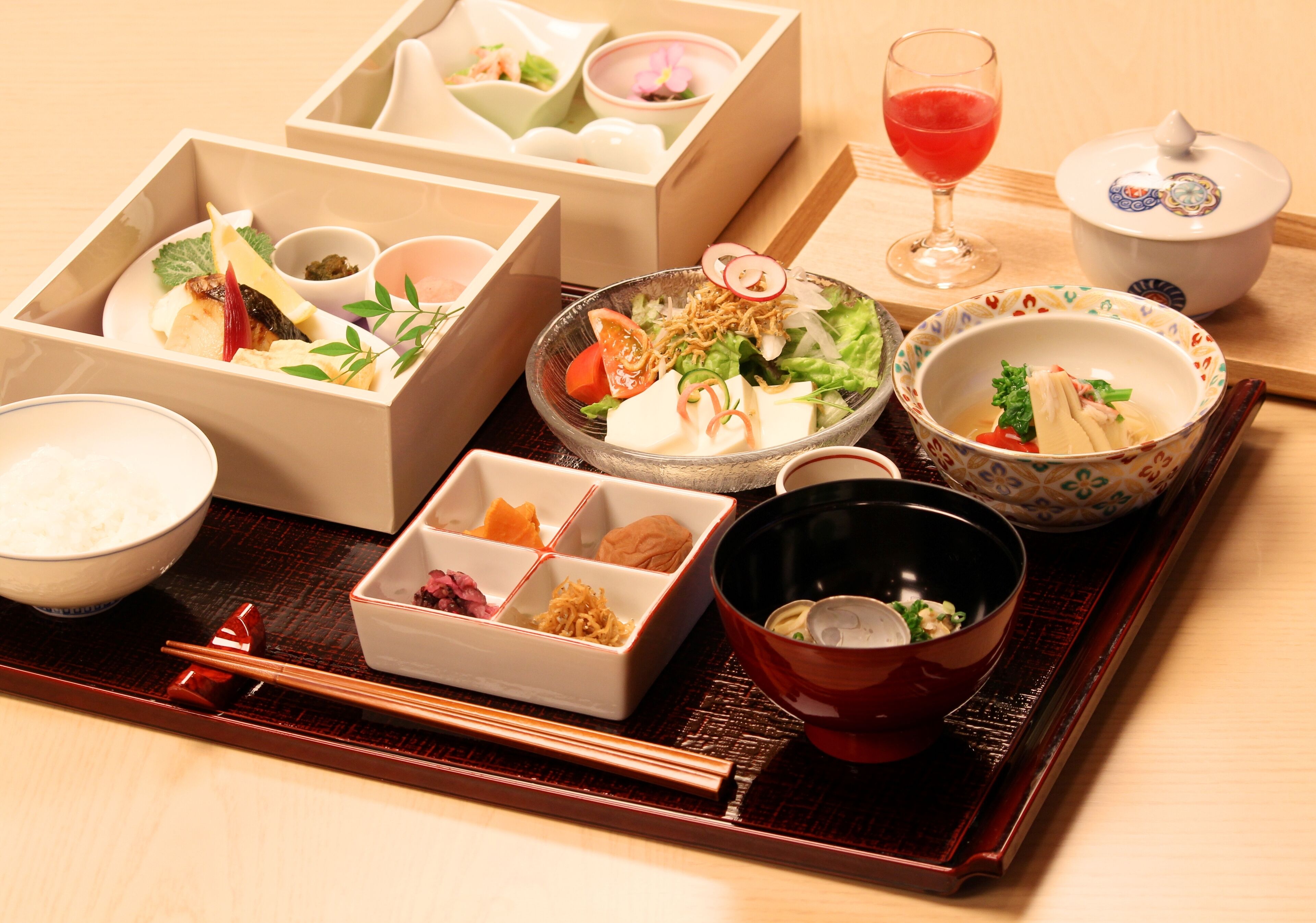 A traditional Japanese meal setup with various dishes and utensils on a tray.
