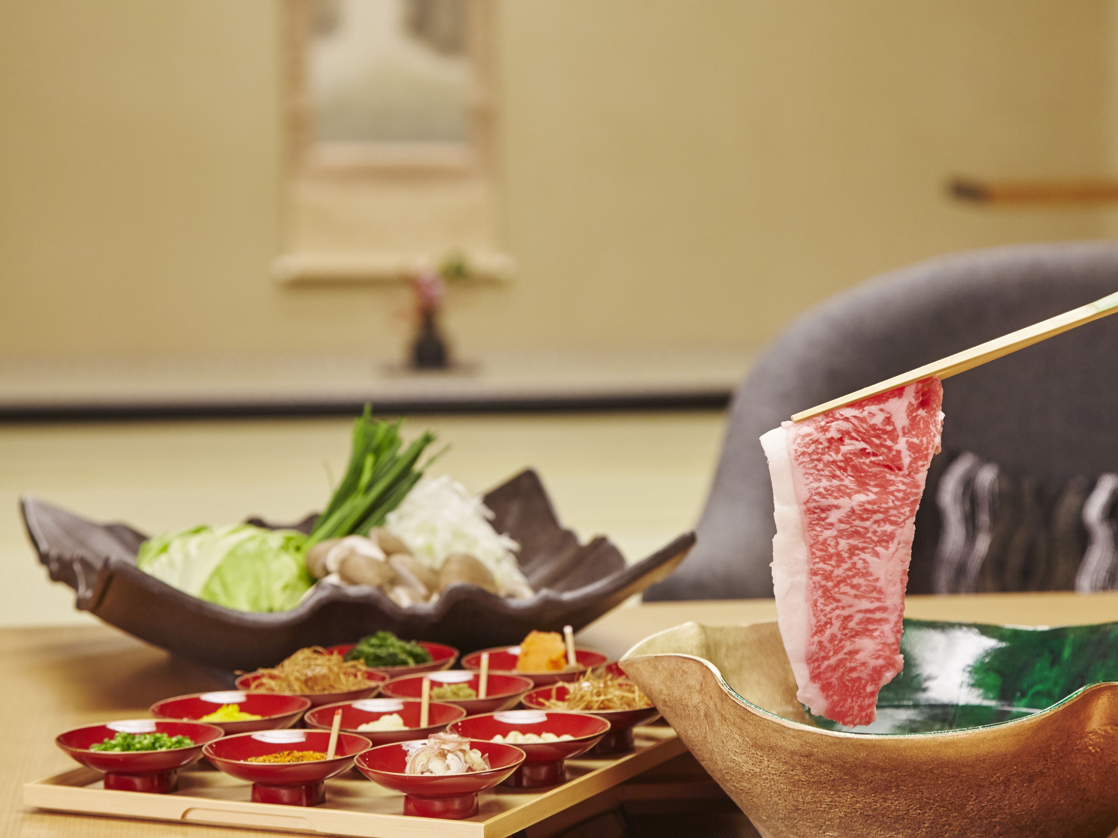 Une table à manger avec différents plats et un ensemble pour préparer une fondue.