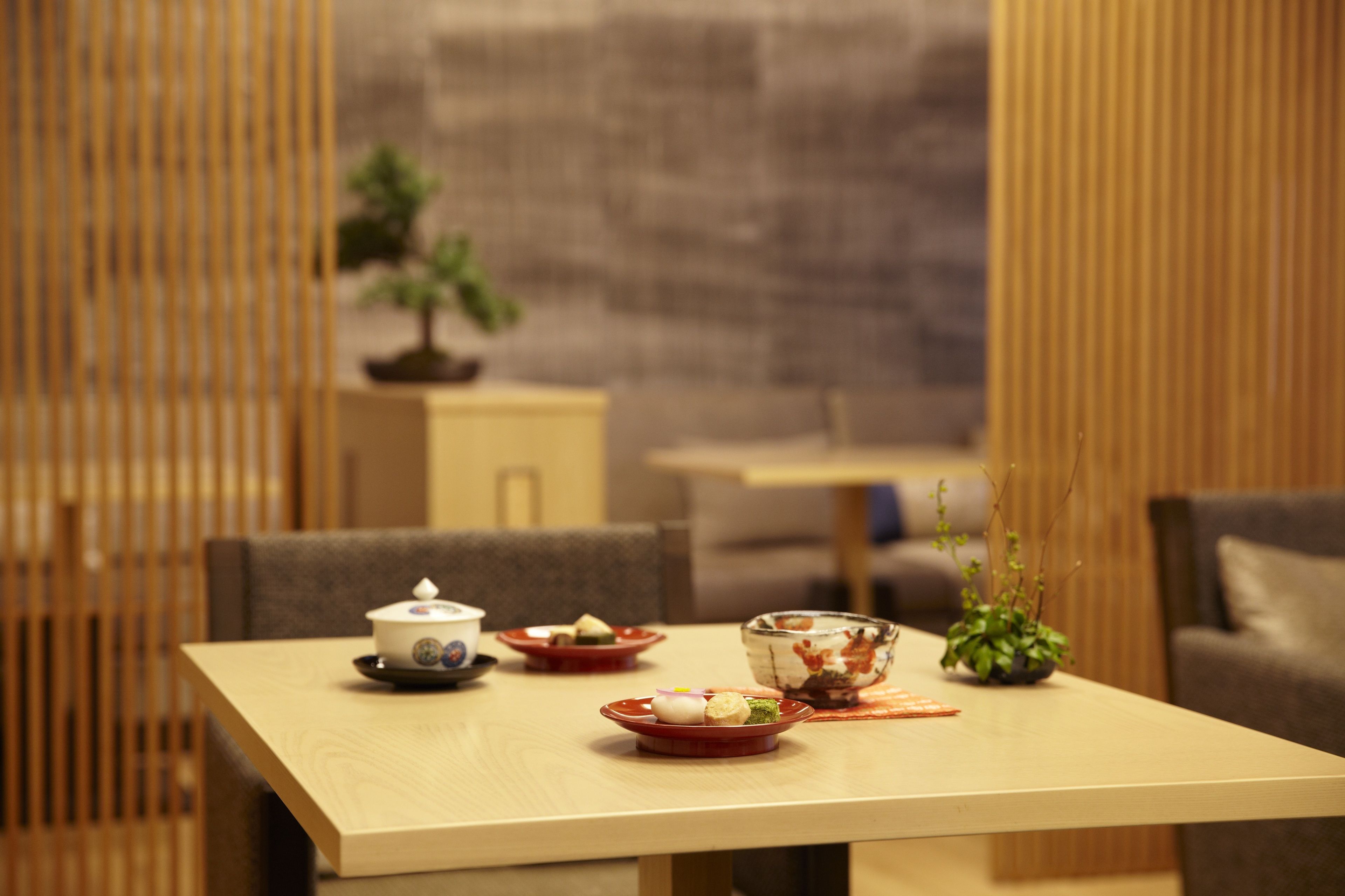 A dining table with plates of food, a bowl, and a small potted plant.