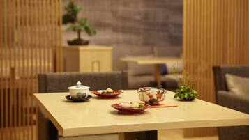 A dining table with plates of food, a bowl, and a small potted plant.