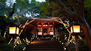 A traditional Japanese structure with a staircase leading up to it, surrounded by trees and illuminated by lanterns. - Takanawa Hanakohro, a Member of Small Luxury Hotels of the World (Tokyo)