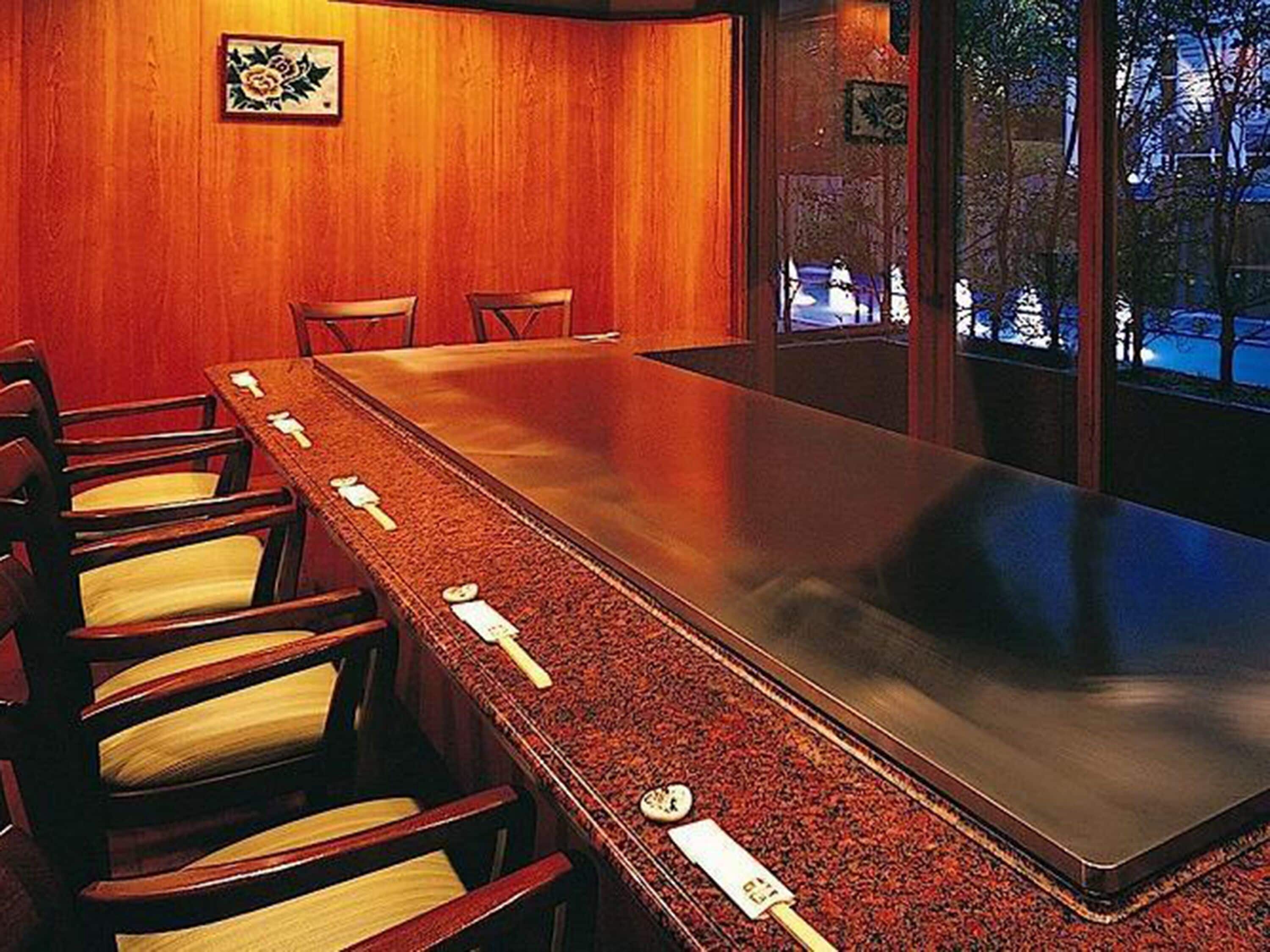 A conference room with a long table and six chairs.