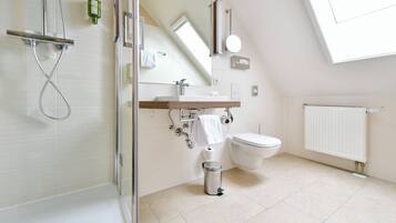 Une salle de bain moderne avec une douche à parois de verre, un meuble-lavabo en bois, des toilettes et un radiateur blanc.
