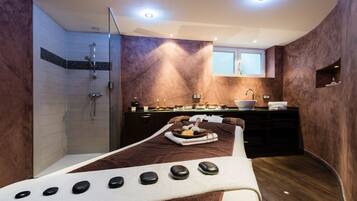 Experience relaxation in this serene spa room, featuring a massage table, shower, and vanity for a tranquil retreat.