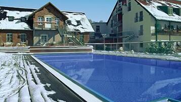 Una piscina con nieve en el borde circundante.