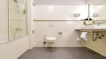 Ein modernes Badezimmer mit Duschkabine aus Glas, Toilette und Waschbecken mit Handtuchhalter.