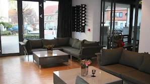 Un salon moderne avec un canapé, deux tables basses et un vase décoratif.