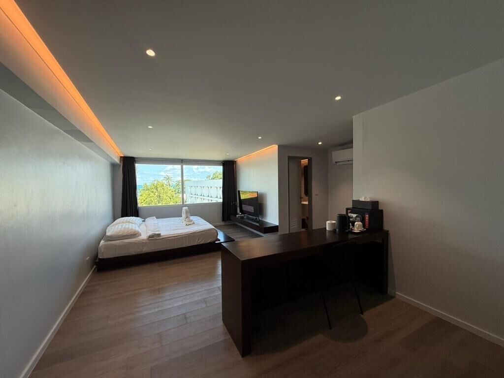 A modern room with a bed, a desk, and a TV.