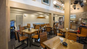 A restaurant with multiple tables and chairs, a pool table, and a water dispenser. - P168 Hostel Samui (Koh Samui)