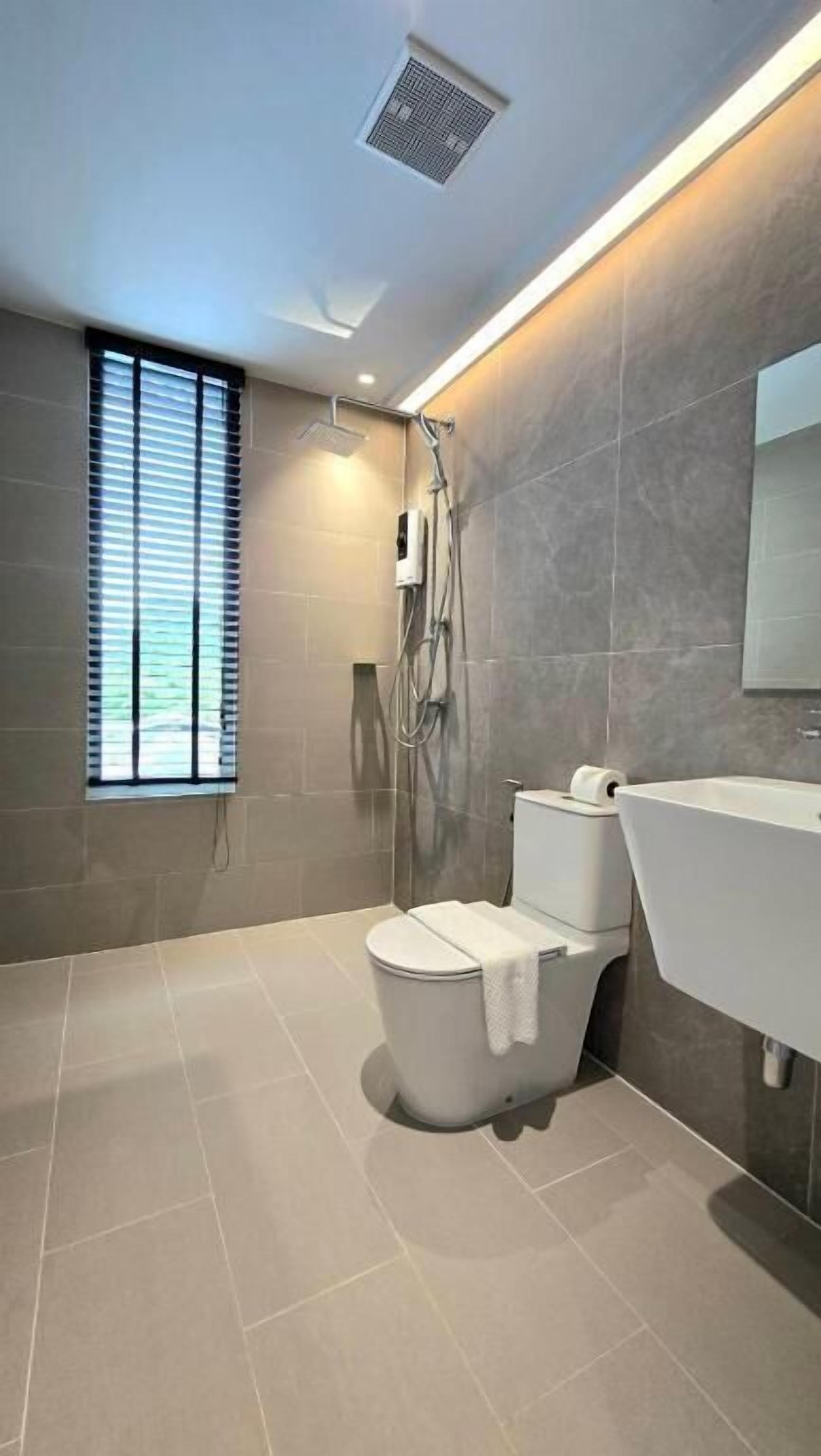 Une salle de bain moderne équipée de toilettes, d’une douche et d’un lavabo.
