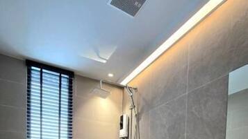 Une salle de bain moderne équipée de toilettes, d’une douche et d’un lavabo.