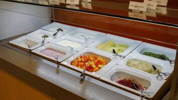 A buffet with various food items and utensils.