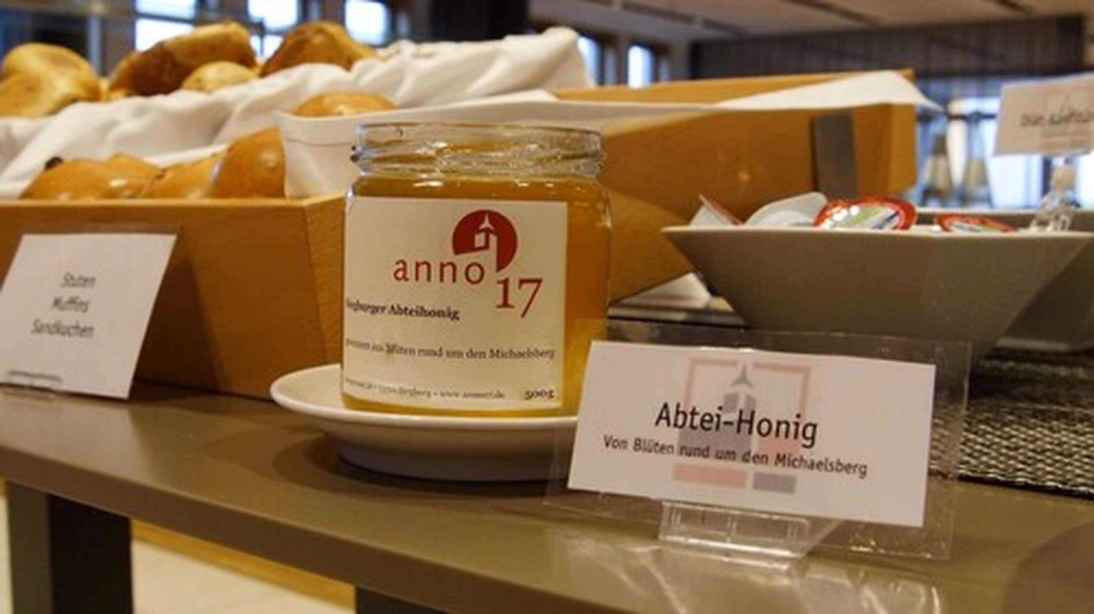 Une exposition de produits alimentaires comprenant un bocal étiqueté « Anno 17 » et une pancarte indiquant « Abtei-Honig ».