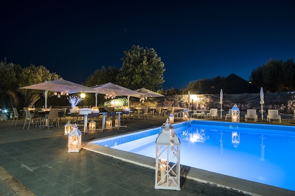 Una piscina al aire libre, sillones reclinables de piscina