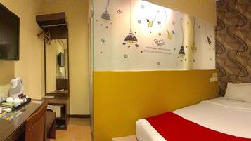 A hotel room with a bed, a desk with a telephone, a television, and a mirror.