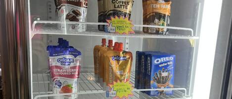 A refrigerated display case with various beverages including milk, coffee, and energy drinks.