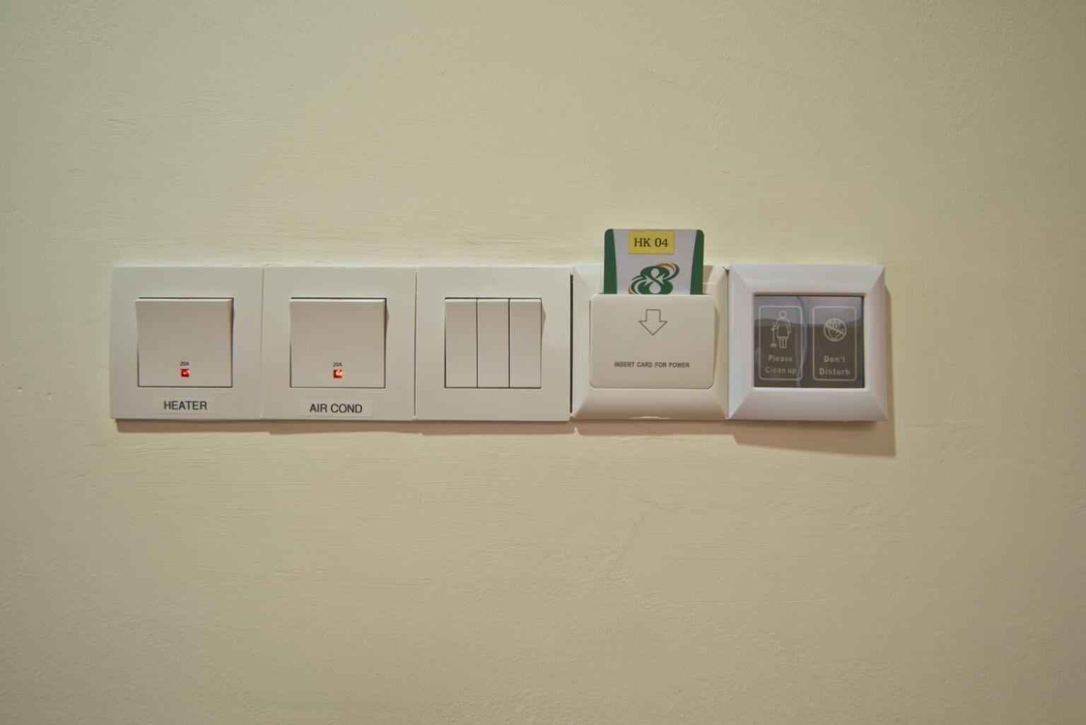 Un panel de control montado en la pared con un calentador, aire acondicionado y lector de tarjetas para la conexión eléctrica.