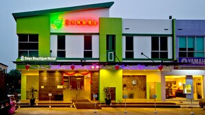 A hotel with a green and white facade, a sign indicating '8 Days Boutique Hotel', and a Yamaha store across the street. - Eight Days Boutique Hotel (Johor Bahru)