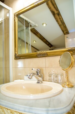A bathroom with a marble sink, a gold-framed mirror, and a small round mirror. - Palazzo Venezia (Zadar)