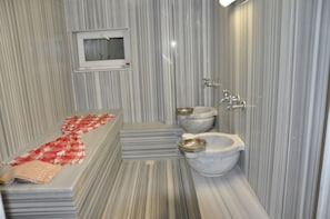 A bathroom with a marble floor, a window, a toilet, and a bidet. - Dragos Island Hotel (Istanbul)