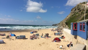 A beach with tents and people. - The Beach House & Porth  Sands Apartments (Newquay)