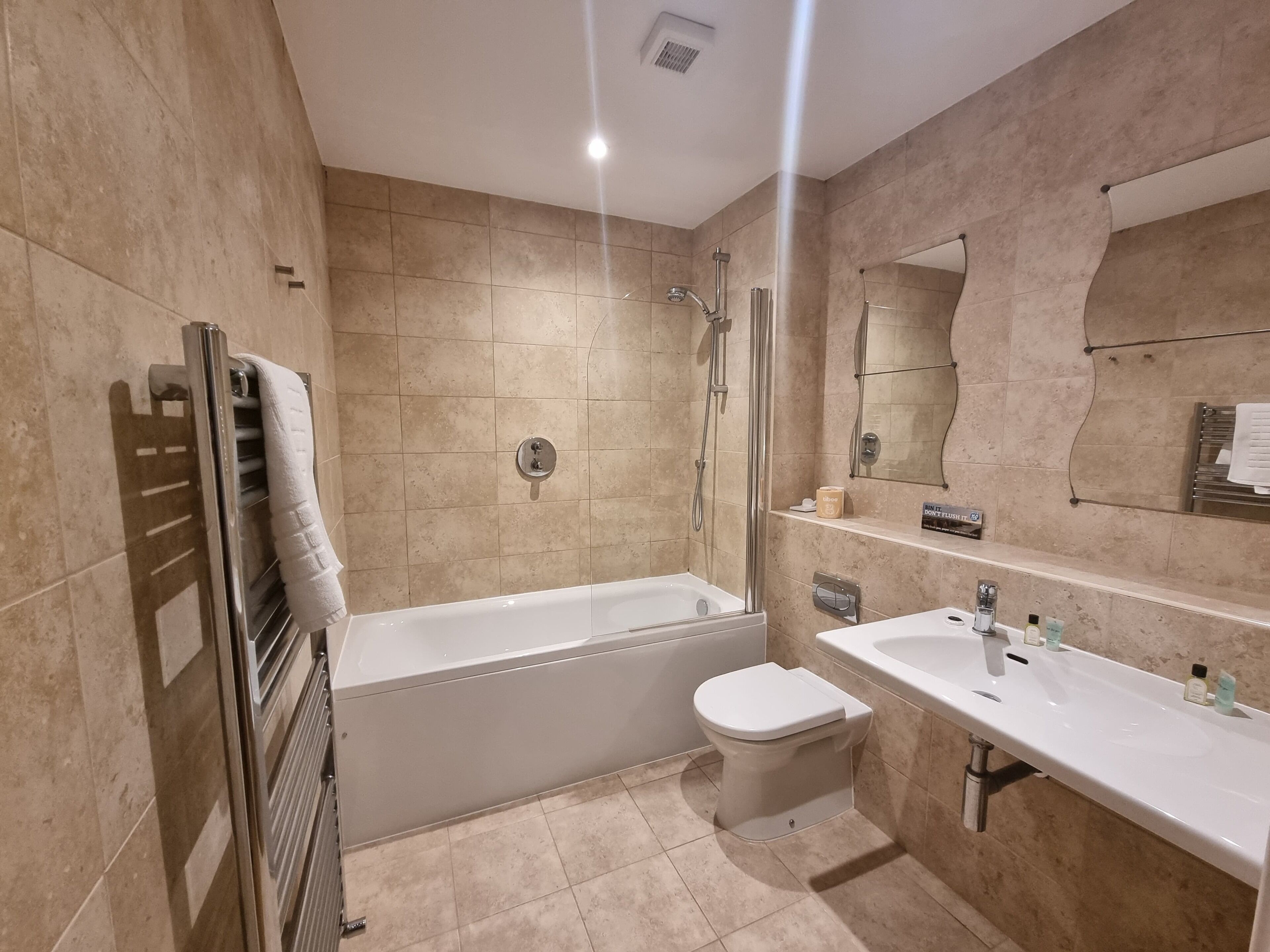 A modern bathroom with a bathtub, toilet, and sink.