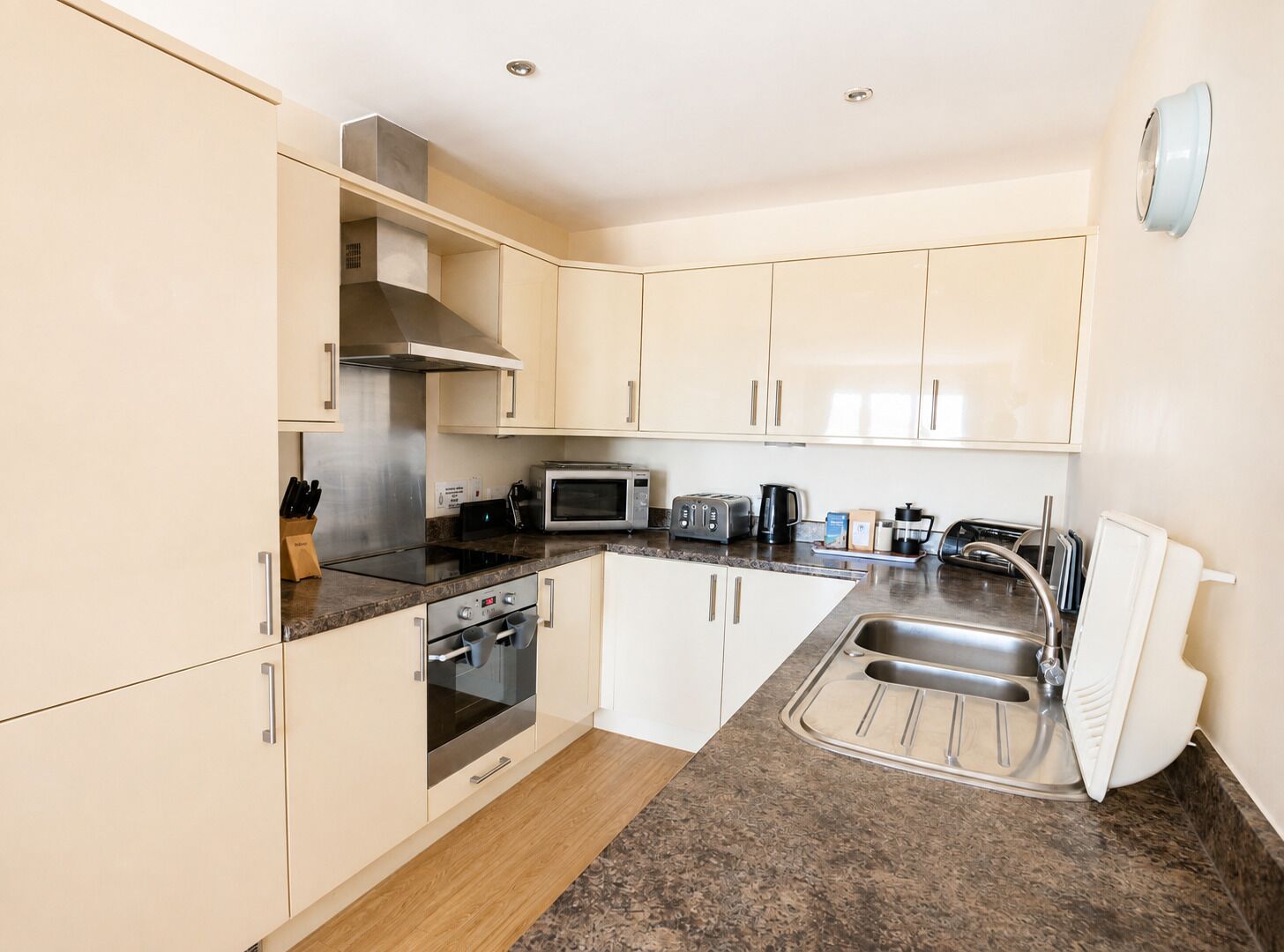 A modern kitchen with stainless steel appliances, a microwave, toaster, and a sink.