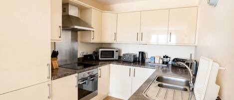 A modern kitchen with stainless steel appliances, a microwave, toaster, and a sink.