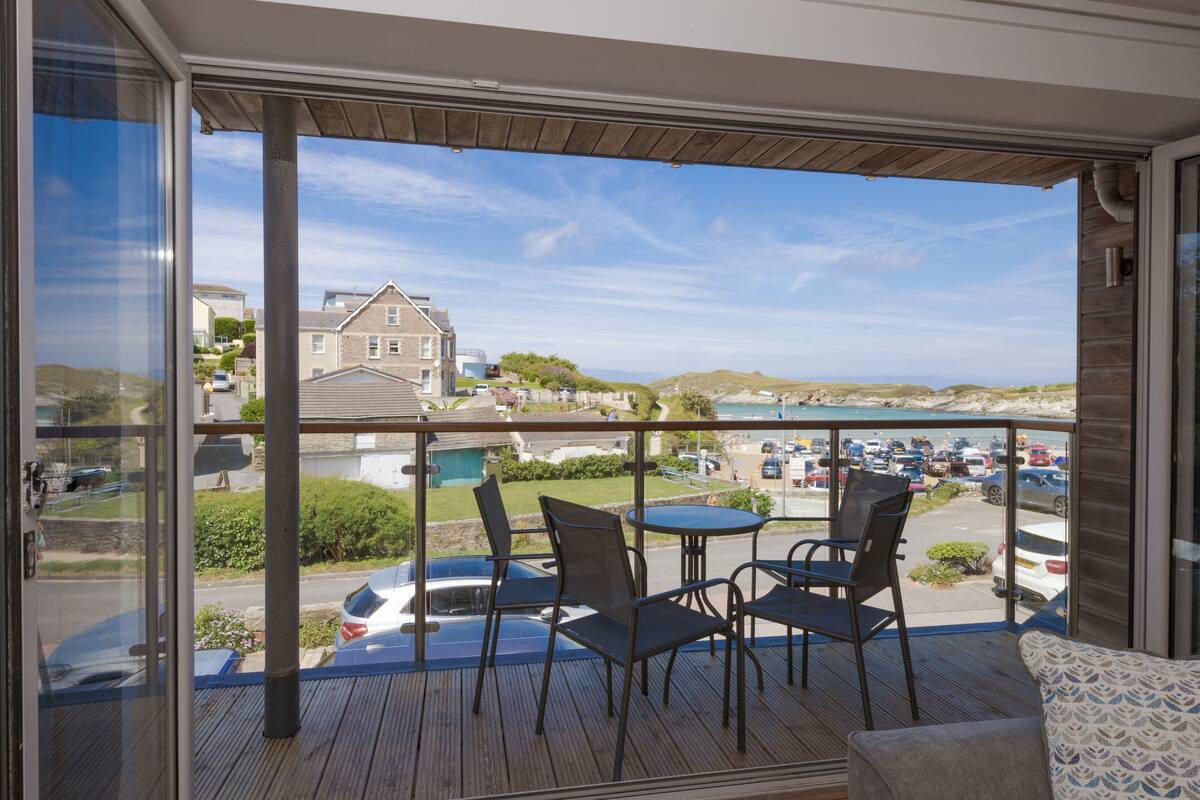 Un balcon donnant sur un parking et des maisons.