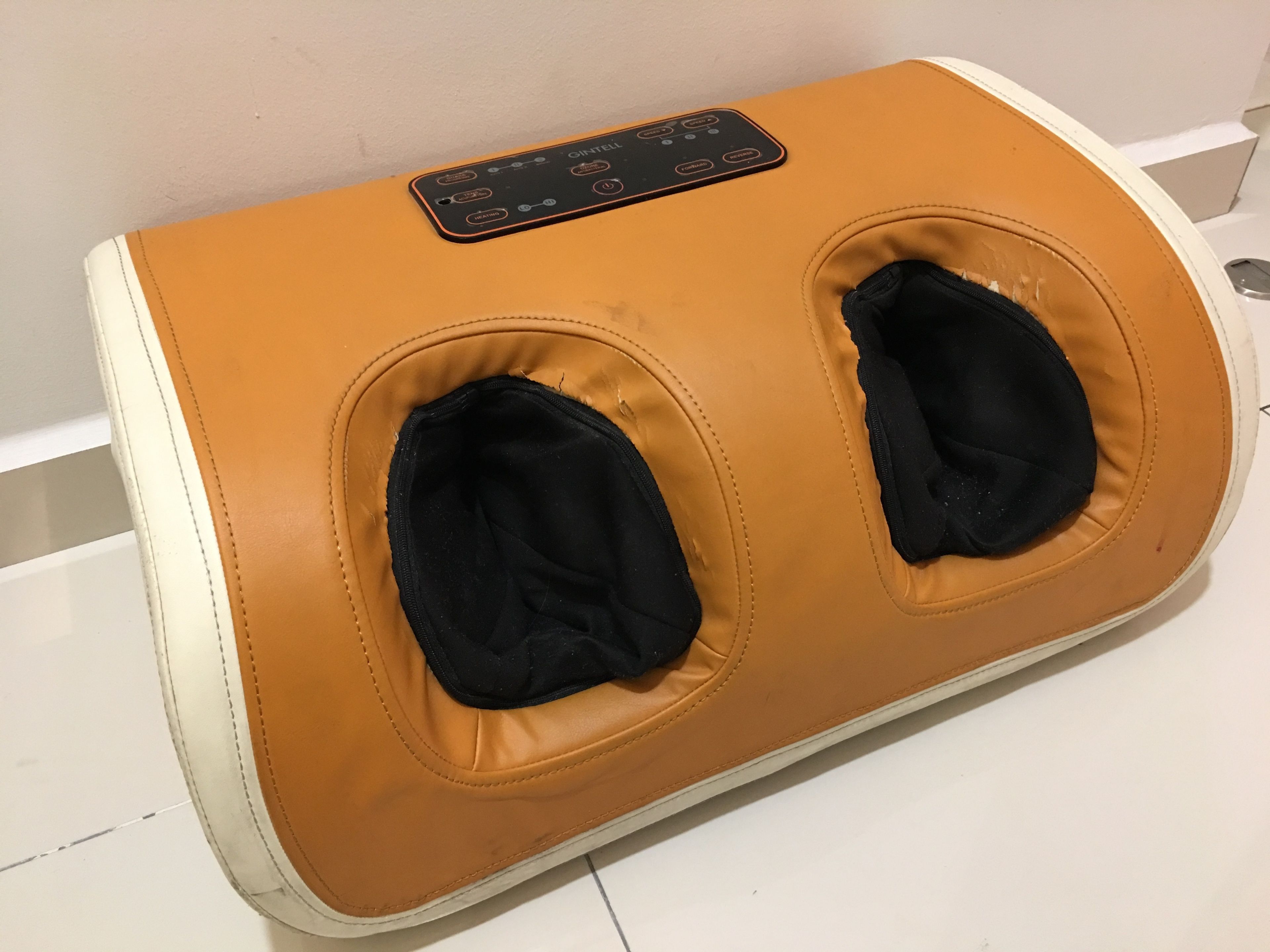 A massage chair with a control panel and two footrests.