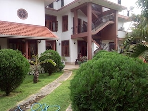 A two-story house with a red-tiled roof, a balcony with a black railing, and a staircase leading to the upper floor. - Norfolk Heritage Airport Villa (Seeduwa - Katunayake)