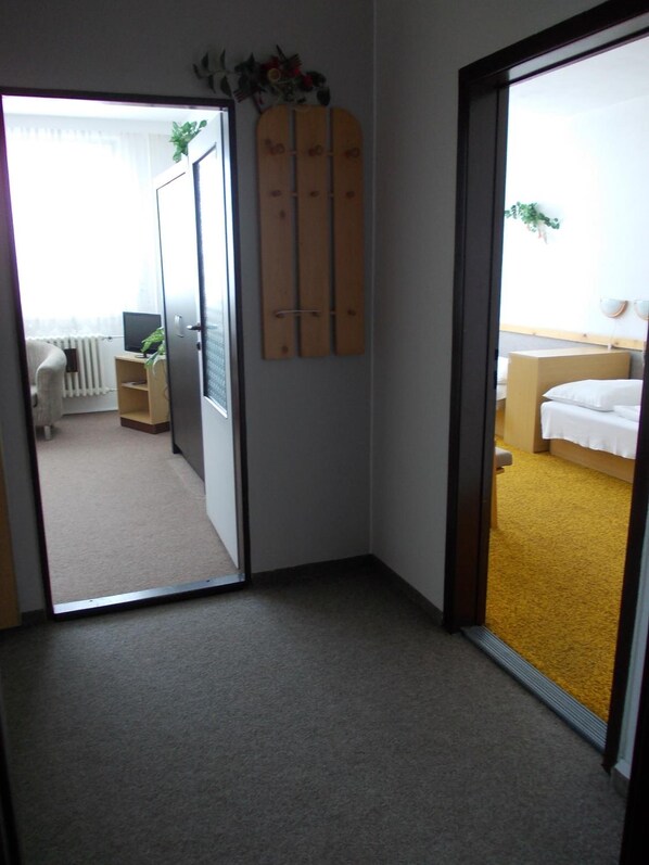 Una habitación de hotel con una cama, un escritorio pequeño, una silla, un radiador y una ventana.