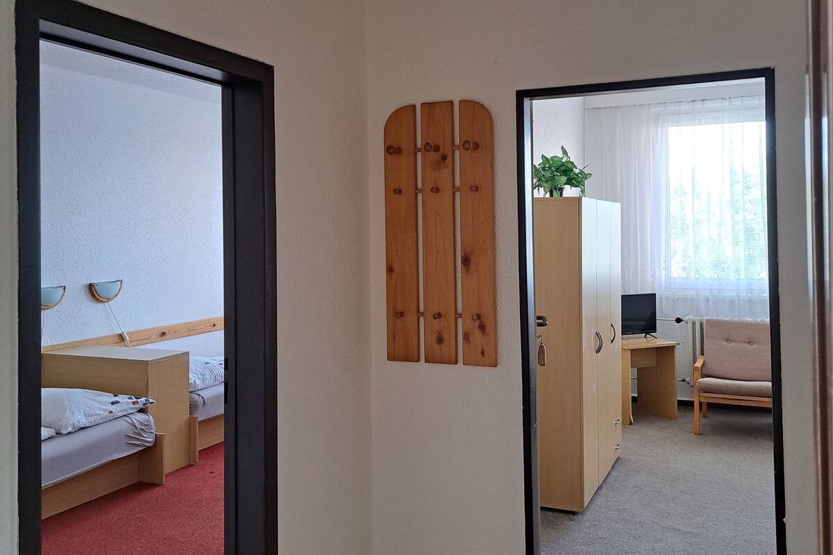 A room with a bed, a desk, a chair, and a wardrobe.