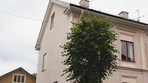 Un edificio de dos pisos con un árbol en frente.