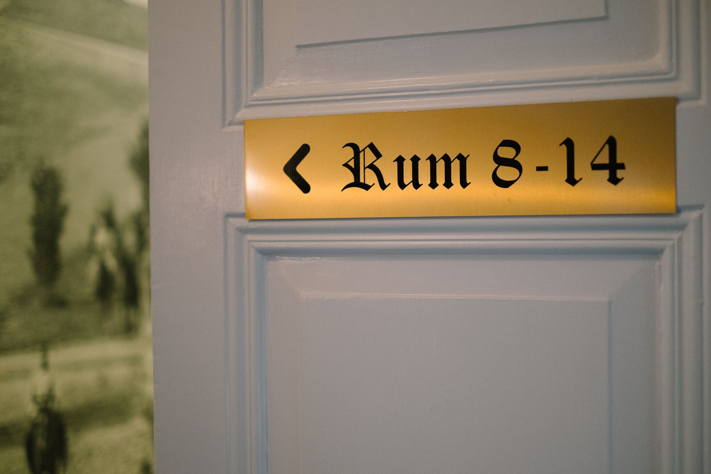 A door with a sign indicating 'Rumm 8-14'.