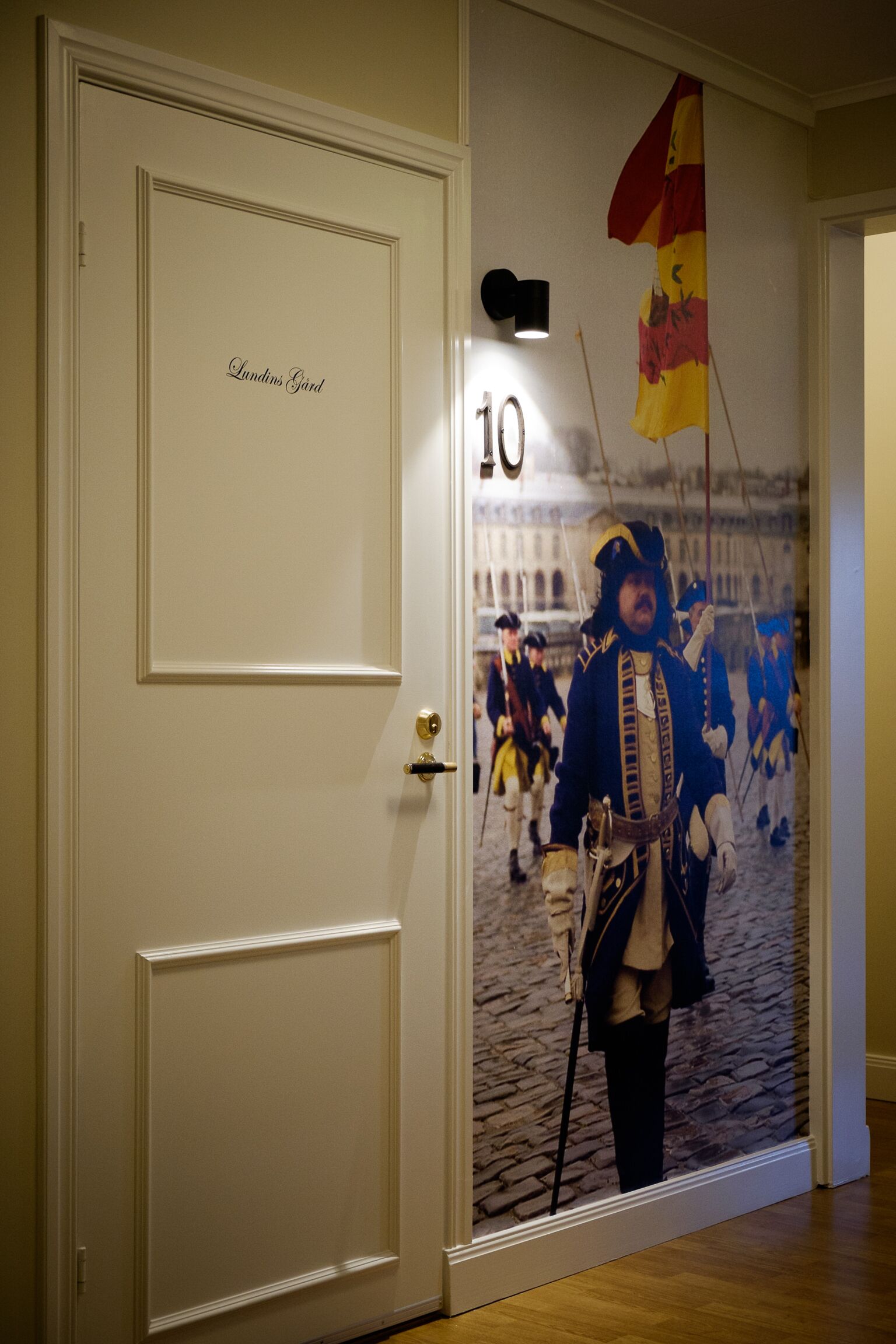 A door with a number 10 sign and a mural of a historical scene with soldiers.