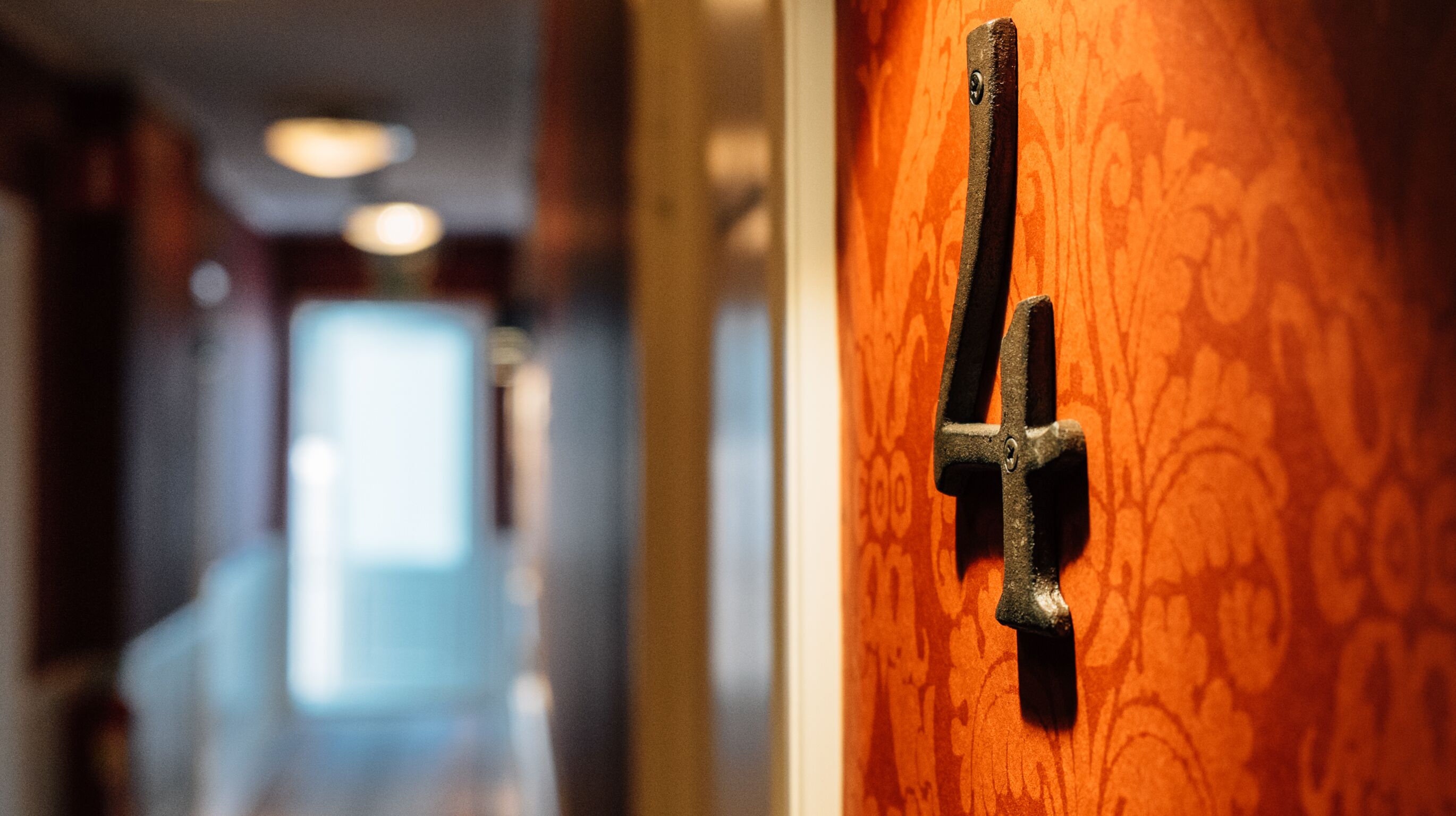 Un gros plan d’une poignée de porte sur une porte en bois ornée d’un motif décoratif.