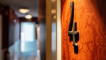 Un gros plan d’une poignée de porte sur une porte en bois ornée d’un motif décoratif.