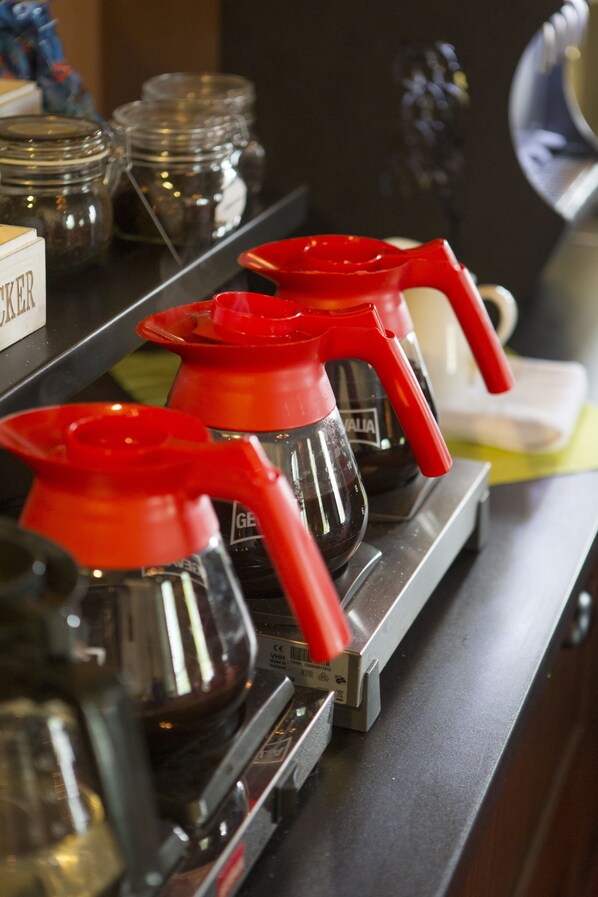 Una estación de café con varias máquinas de café y recipientes sobre una encimera.