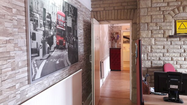 Un couloir avec un mur en briques et une grande affiche représentant une scène de rue.