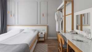 A hotel room with a large bed, bedside table, and a desk with a mirror. - Frapolli 21 (Odesa)