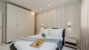 A neatly arranged bedroom with a bed, bedside tables, and a wardrobe. - Apartments Villa Karla (Zadar)