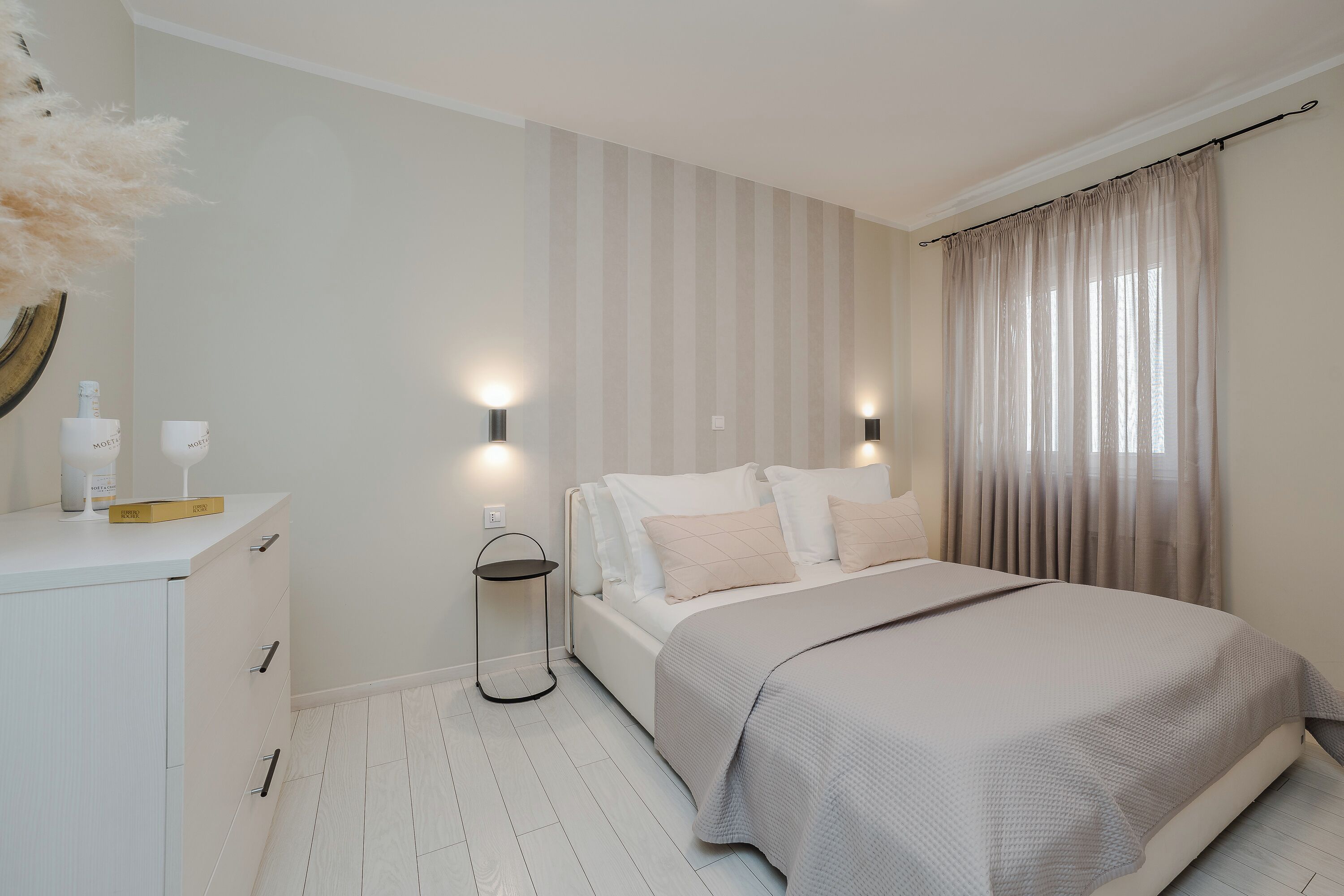 Un dormitorio con cama, mesitas de noche y una mesilla.